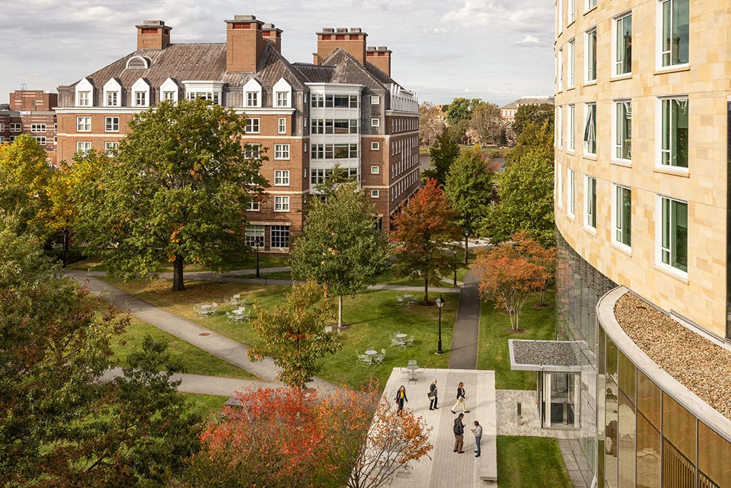 A scenic view of NBS campus with a mix of modern and historic buildings, lush green spaces, and participants congregate in front of Tata