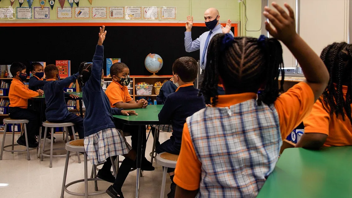 Success Academy students raising hands