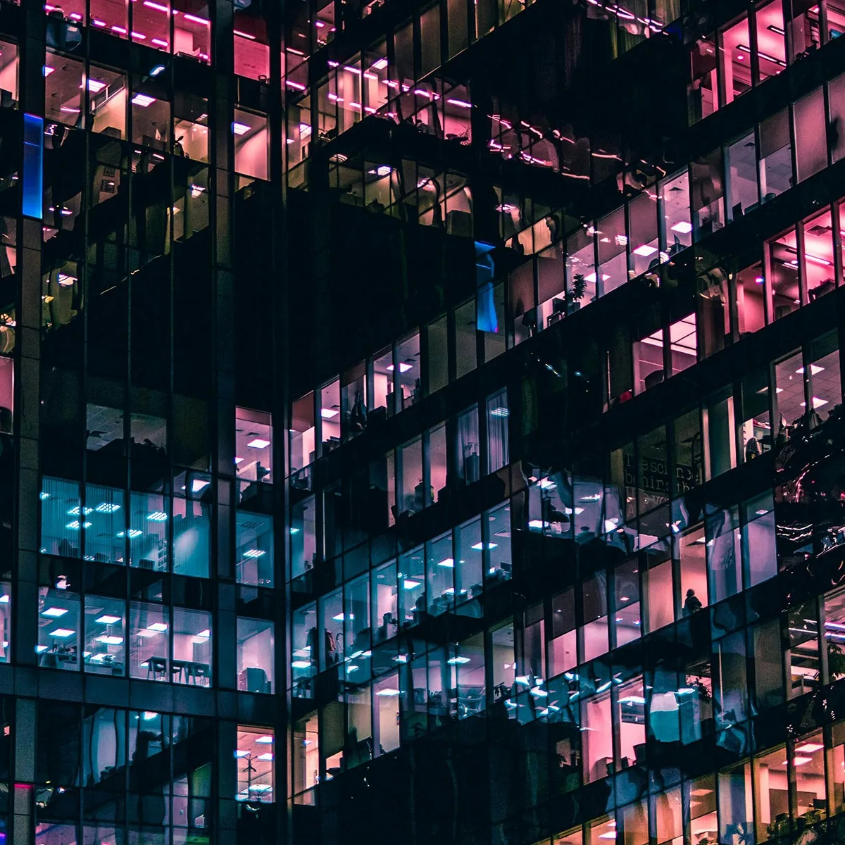 Office windows at night, with multicolored lights. 
