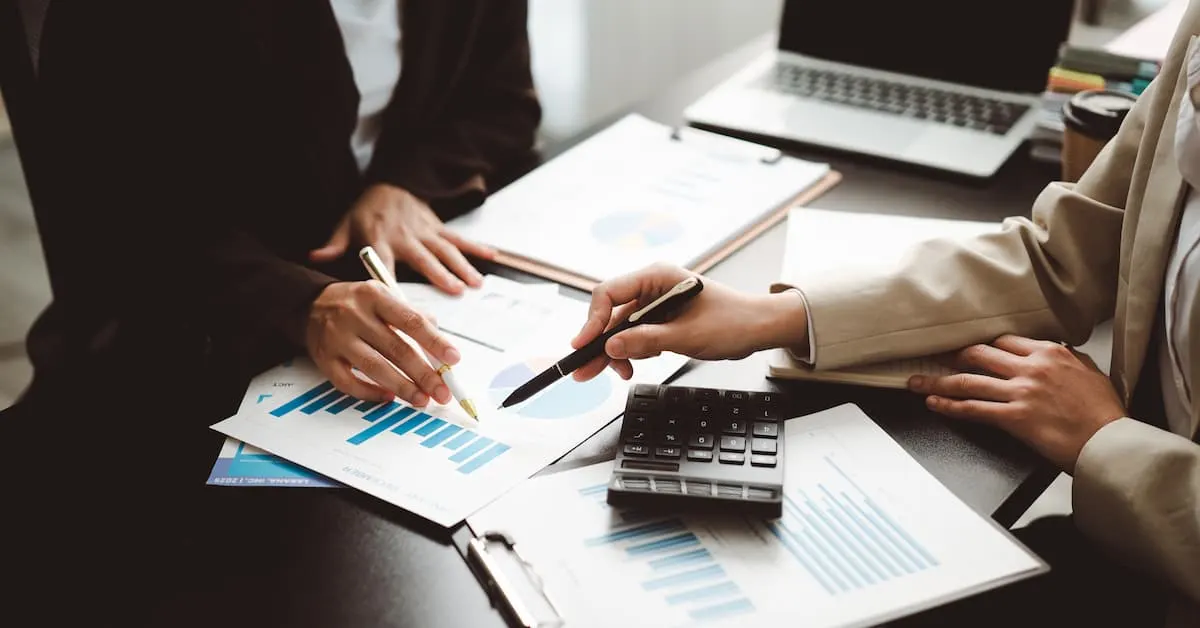 Accountants working together at a desk in a corporate environment. 
