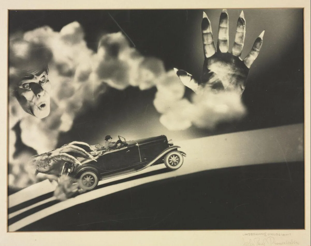 Face floating in cloud of smoke, looking down at his hands holding a car