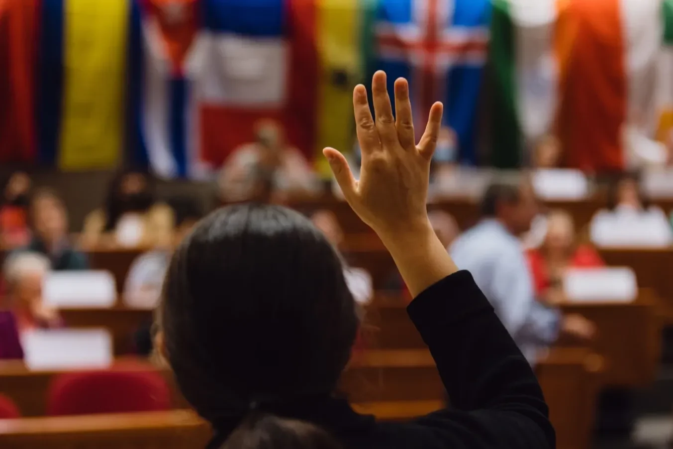 An MBA student raises a hand during a case discussion in a Harvard Business School classroom.