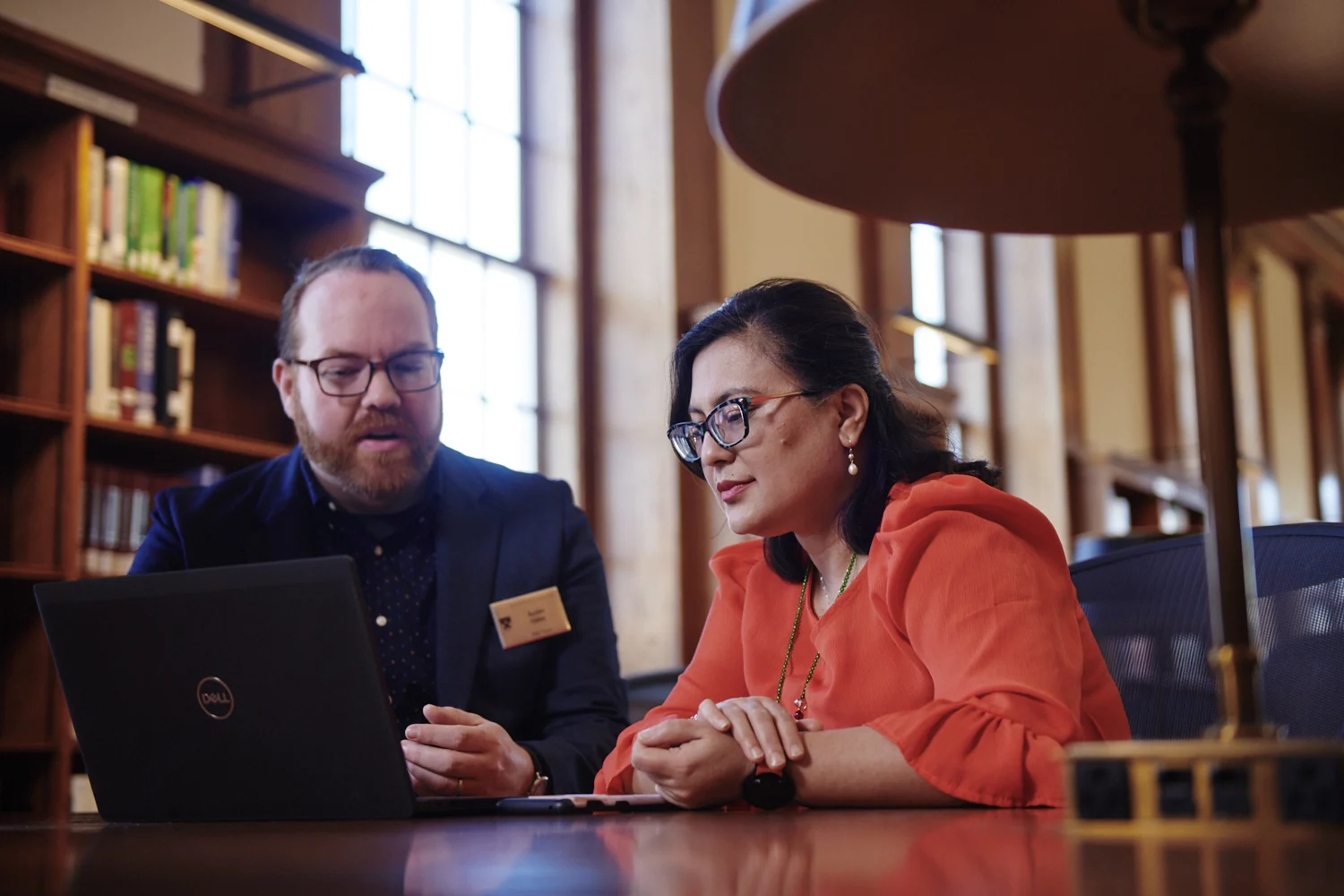 Librarian assisting patron in Baker Library Stamps Reading Room, close up shot.