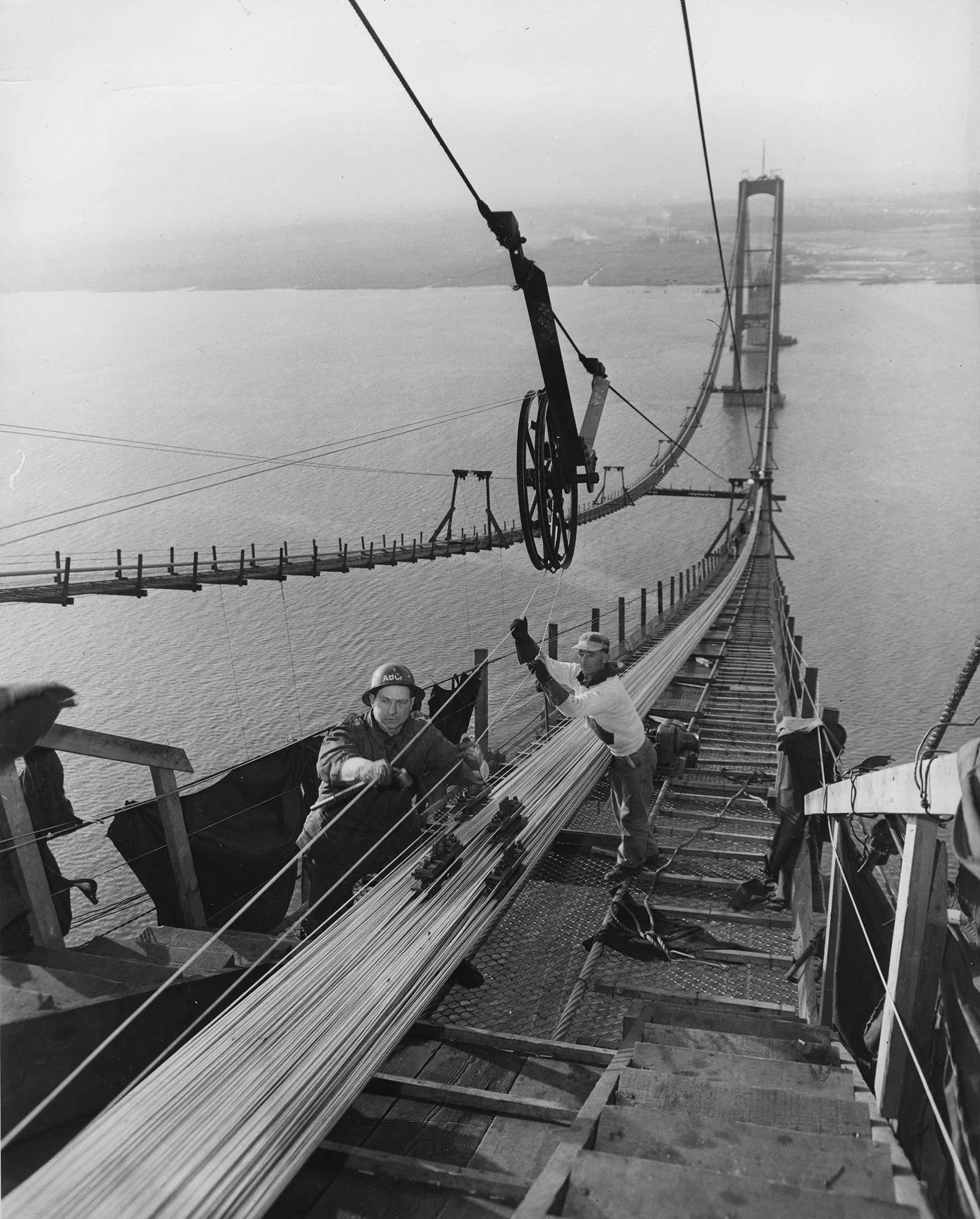 Workers spin wire into suspension cables high above the water on the Delaware Memorial Bridge during its construction.