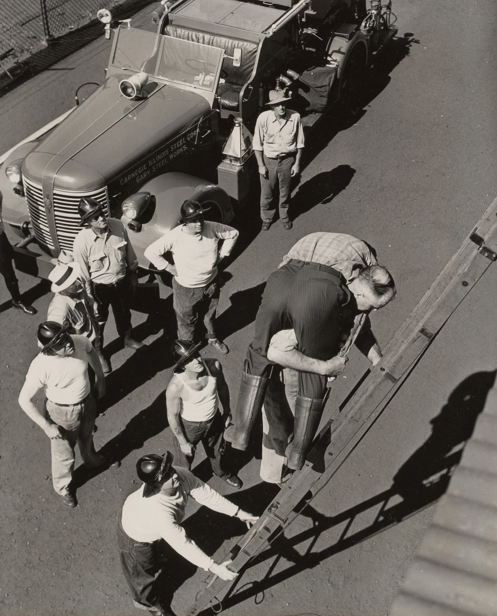 Fire chief demonstrates rescue carry down ladder during safety drill at Gary Steel Works.