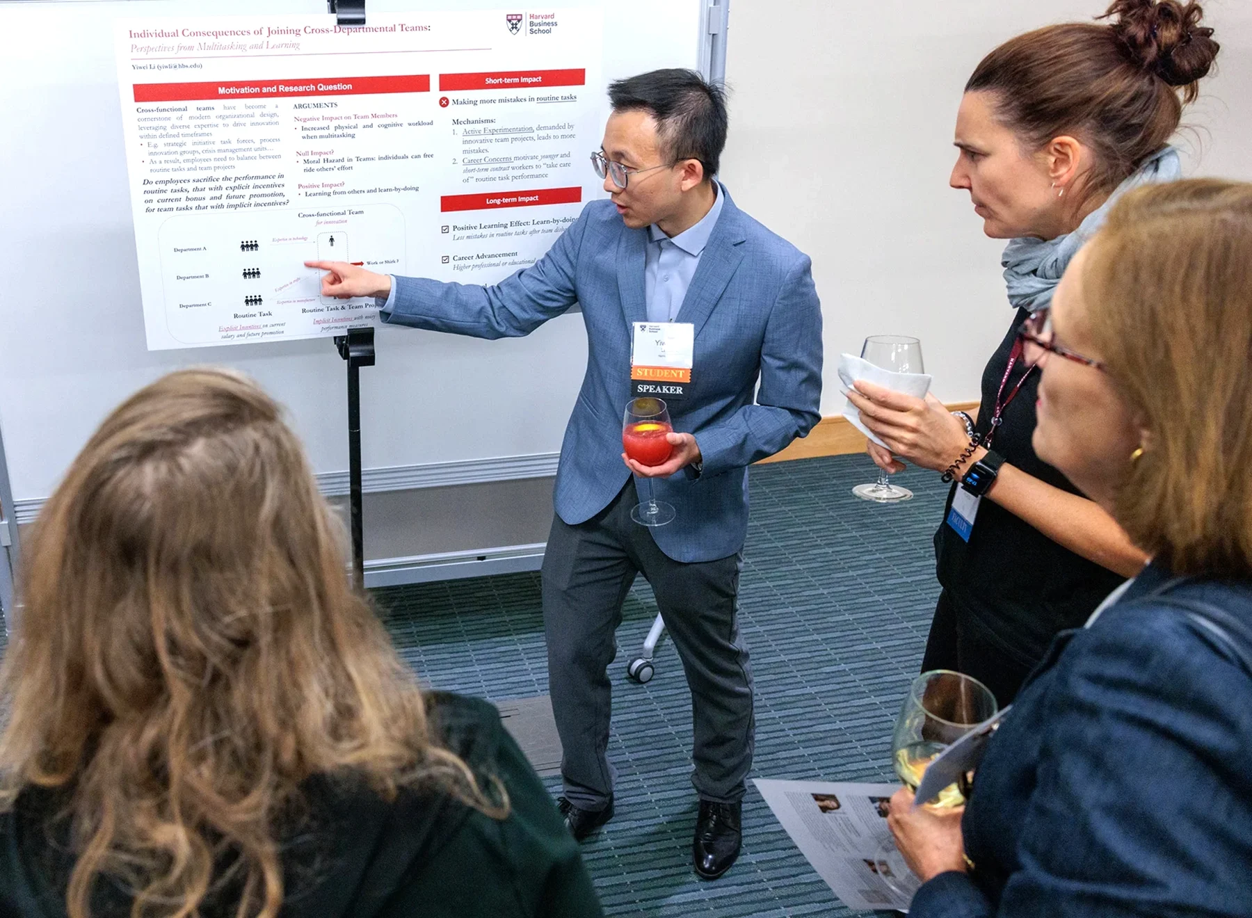 A doctoral student explains his research to members of the faculty.