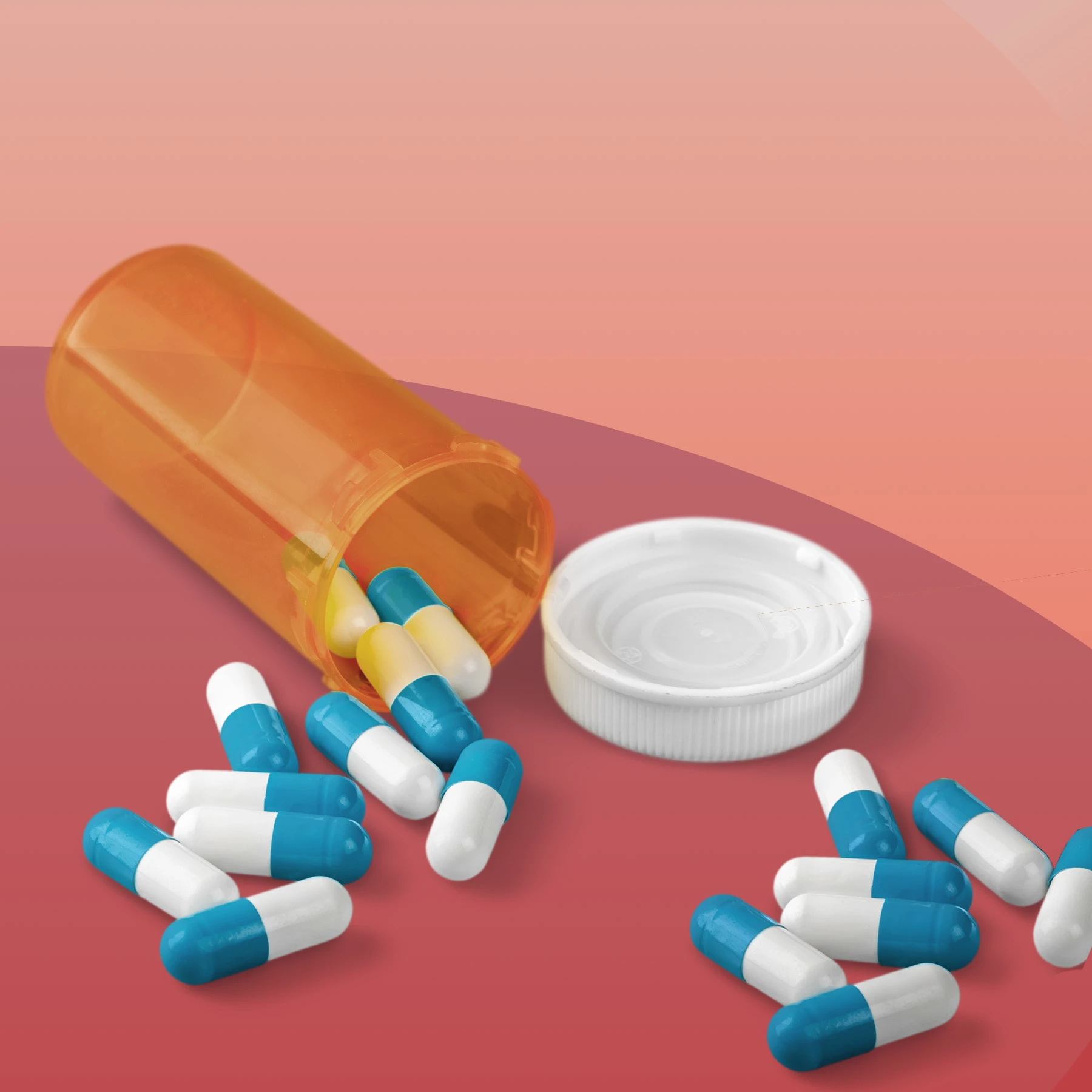 Prescription pill bottle with pills spilling out of it.