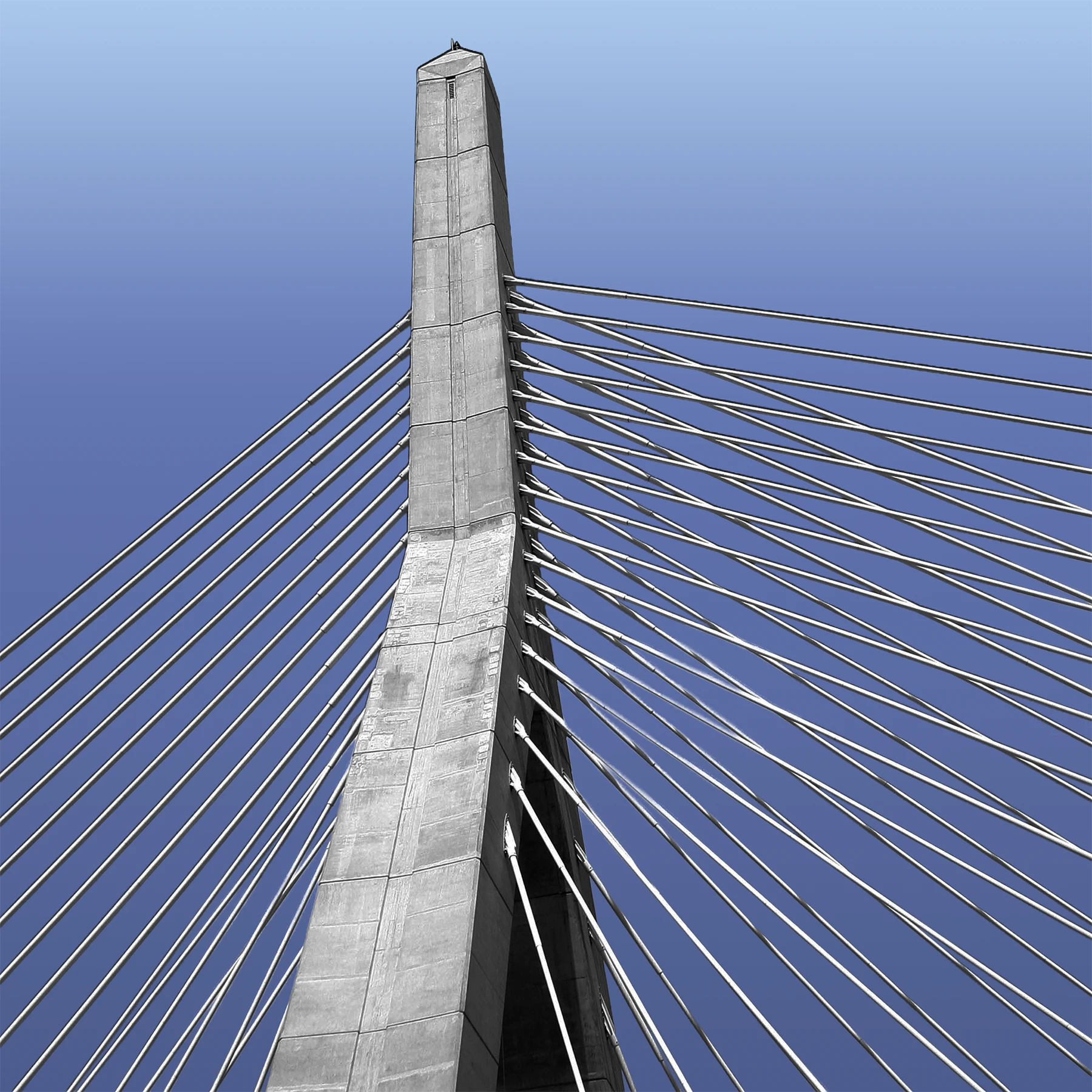 Close-up view of a concrete tower of a cable-stayed bridge, with steel support cables extending diagonally from both sides against a clear blue sky.