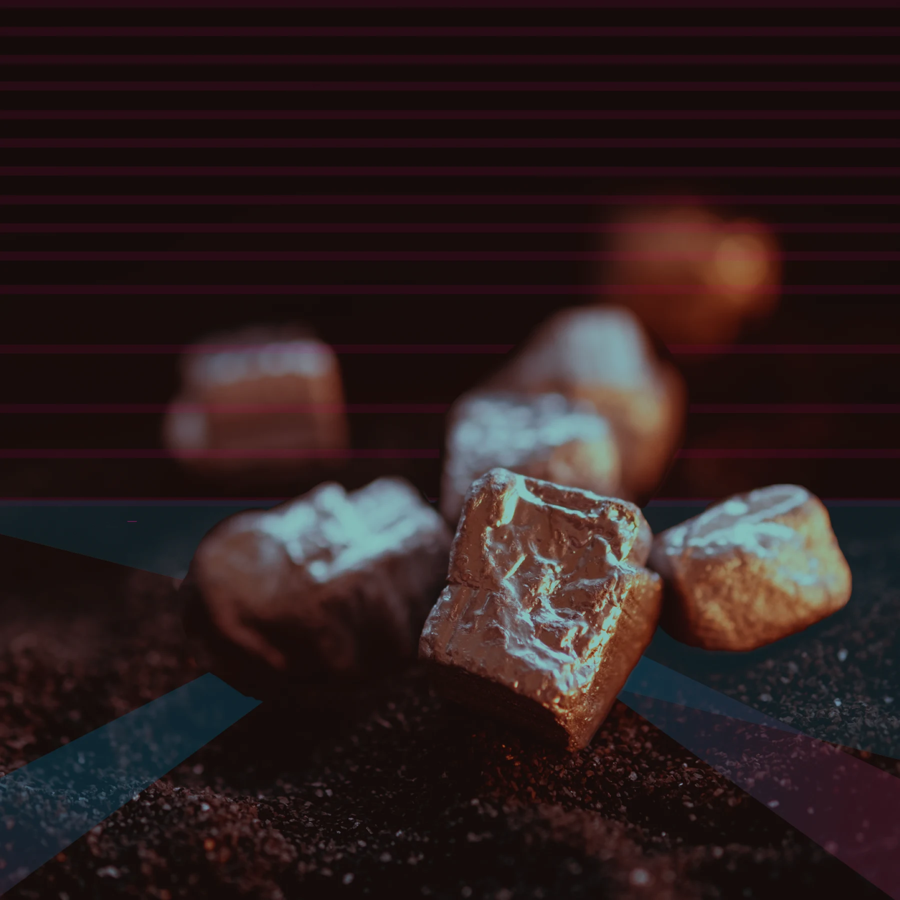 Metallic reddish and teal mineral chunks rest on a dark, sandy surface with a blurred background featuring maroon and teal geometric shapes.