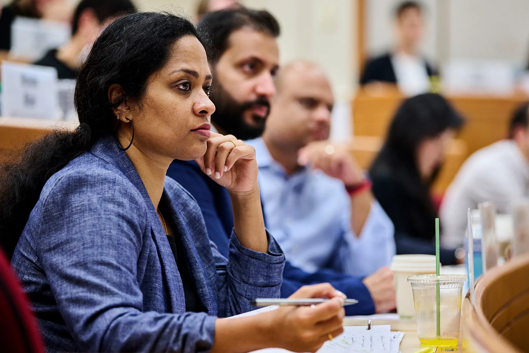 Female executive listens inside the classroom during a lecture and prepares to take notes