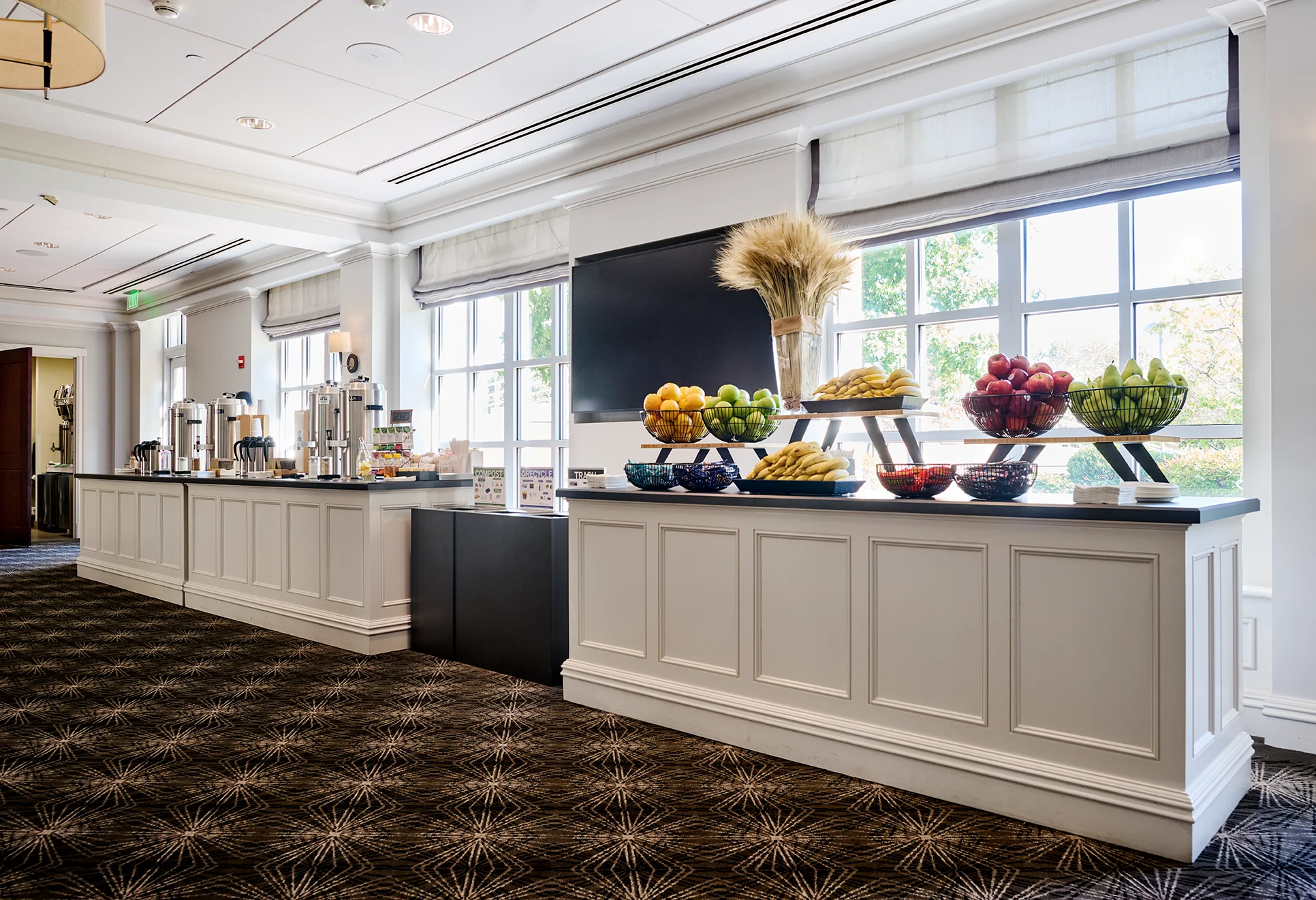 A bright and elegant McArthur refreshment area with fresh fruit, coffee stations, and modern decor