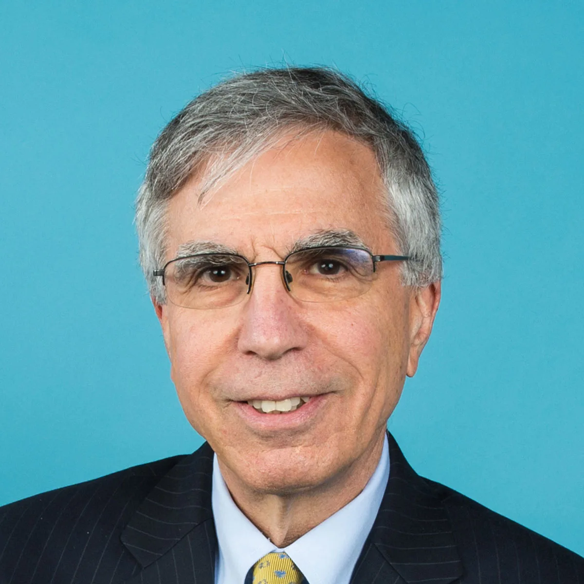 Robert Stavins wearing a yellow tie and jacket