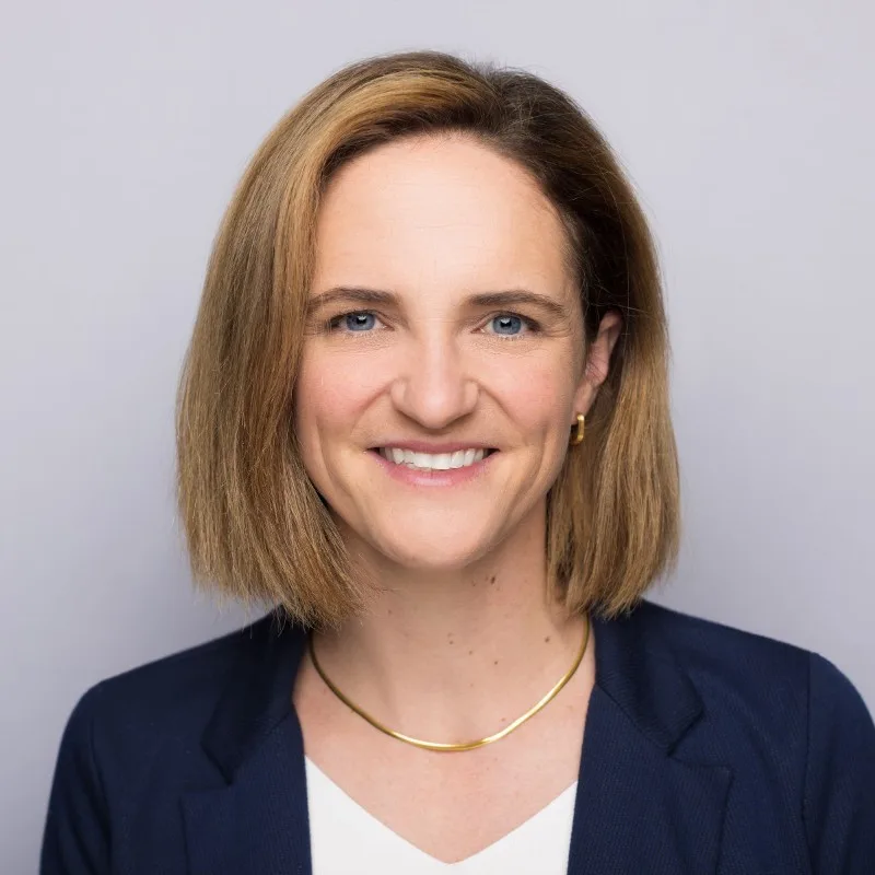 HSPH Professor Michaela Kerrissey's professional headshot, which shows her wearing a suit against a gray backdrop.