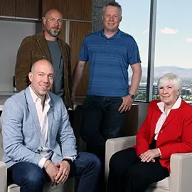 The Miller family of Larry H. Miller Group of Companies sit in white chairs by a window