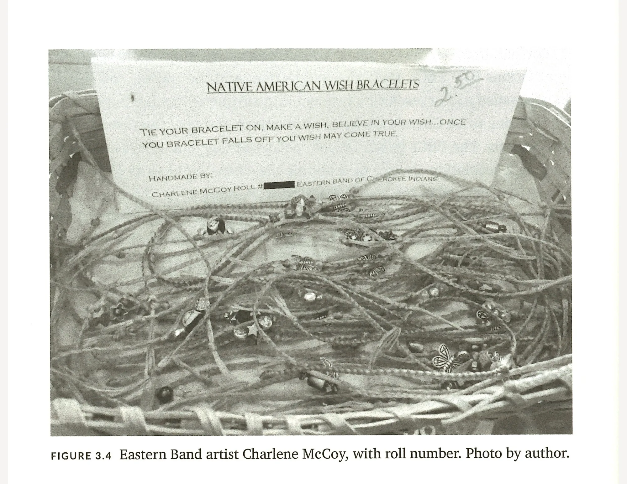 A cluster of woven bracelets in a wicker basket with a sign that says "Native American wish bracekelets" along with a description of a wish bracelet and the name of the artist.