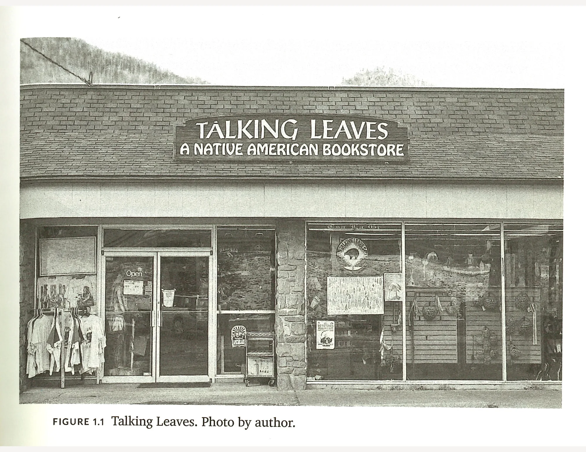The facade of a storefront with a window display, clothes hanging outside, and a large size that says "Talking Leaves: A Native American Bookstore".