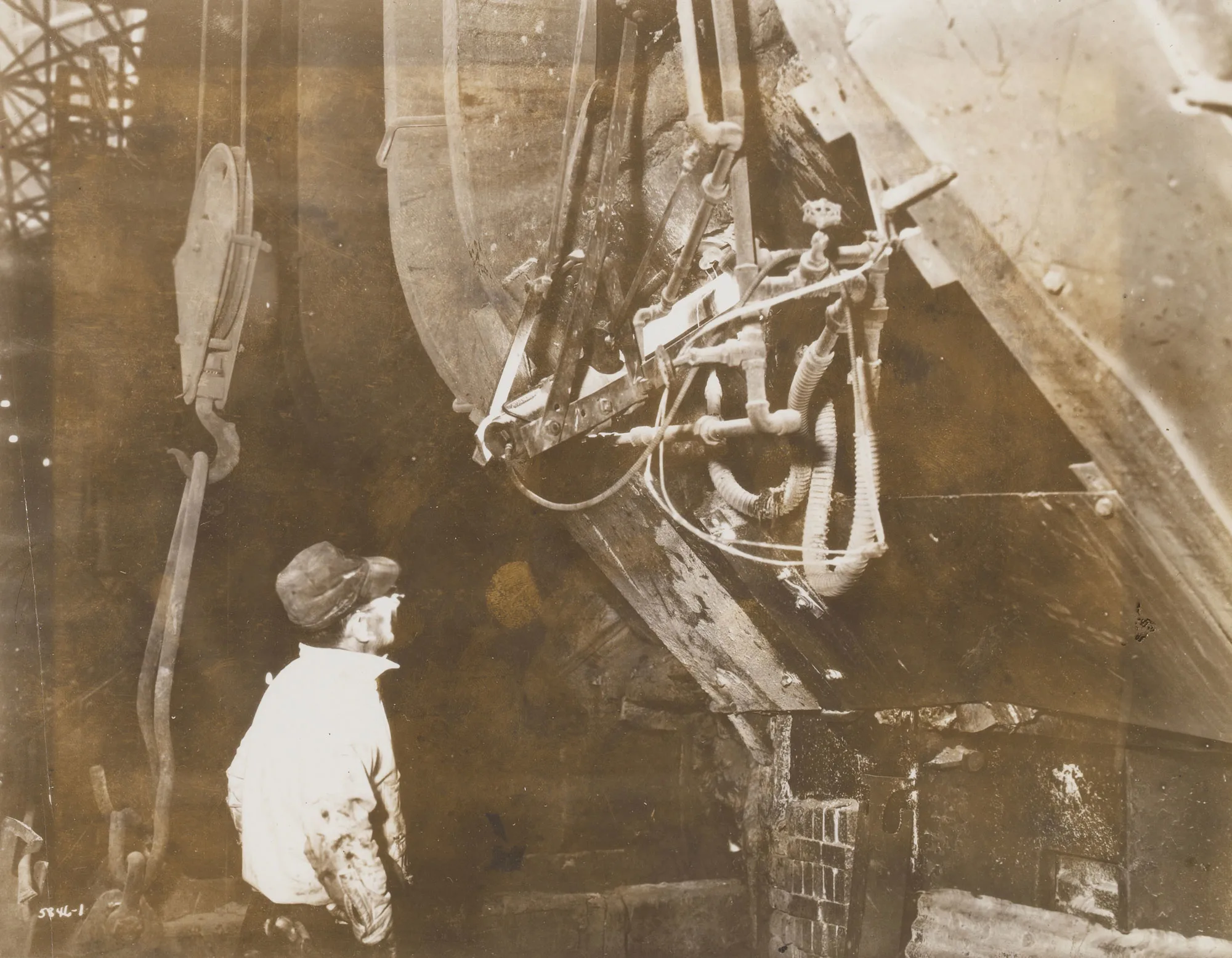 Worker monitors heat progress through electric eye temperature control on furnace at Gary Steel Works.