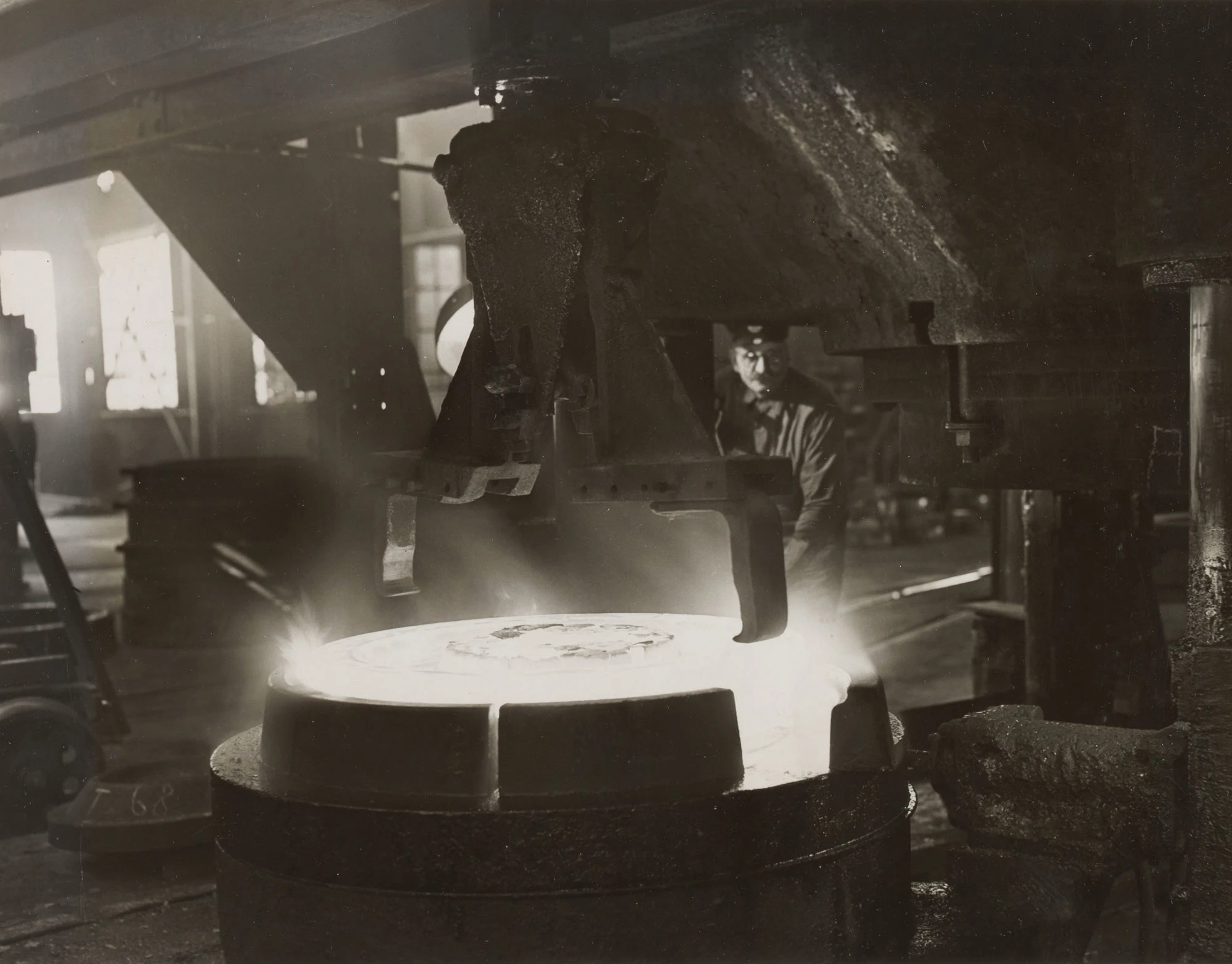 Operator monitors conning press shaping hub and plate of hot railroad wheel at Gary Steel Works.