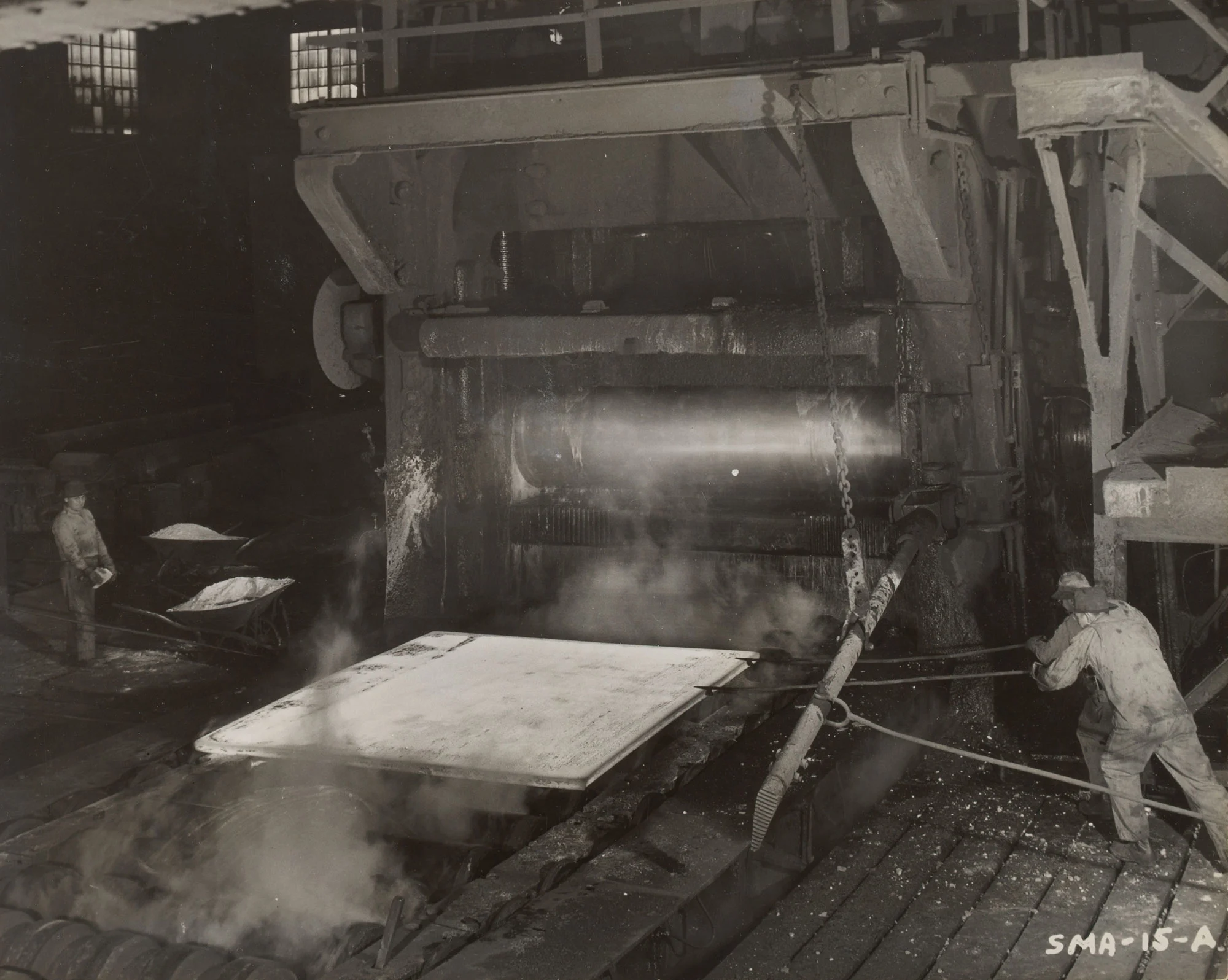 Workers reposition hot steel plate for another pass in 160-inch plate mill at Gary Steel Works.