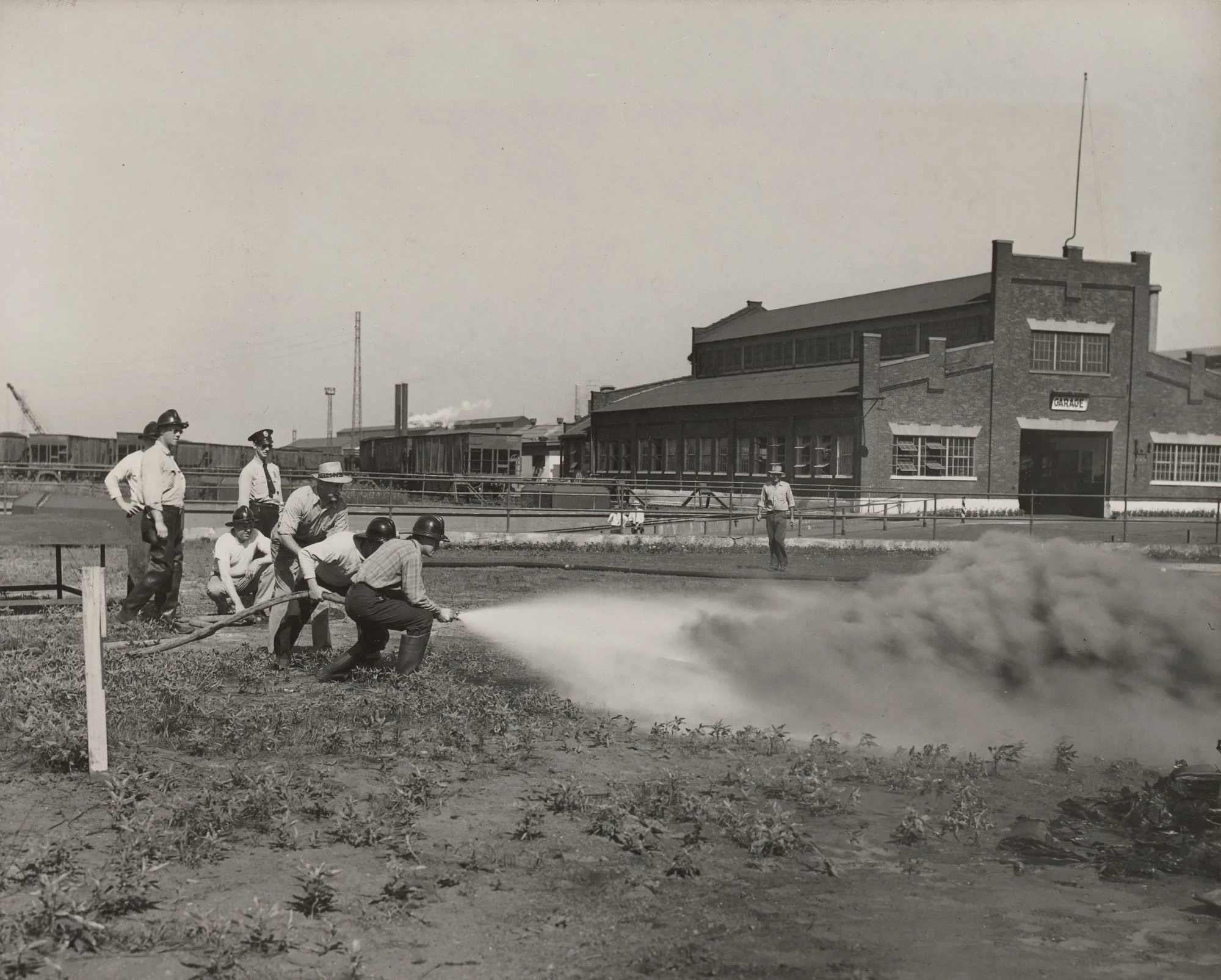 Plant protection crew demonstrates tar fire control using hose and nozzle outside building at Gary Steel Works.