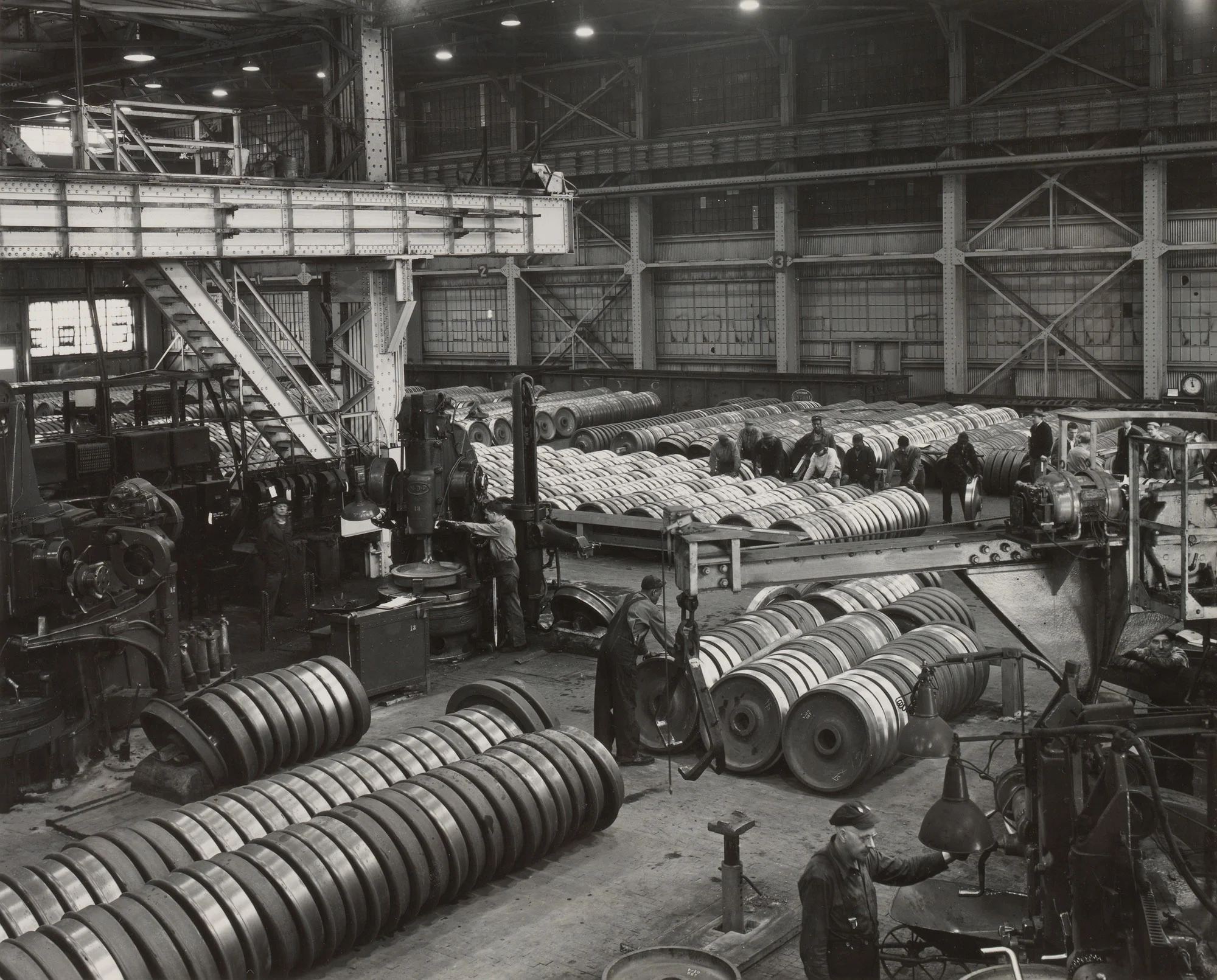 Workers machine and inspect steel railroad wheels before shipment at Gary Steel Works.