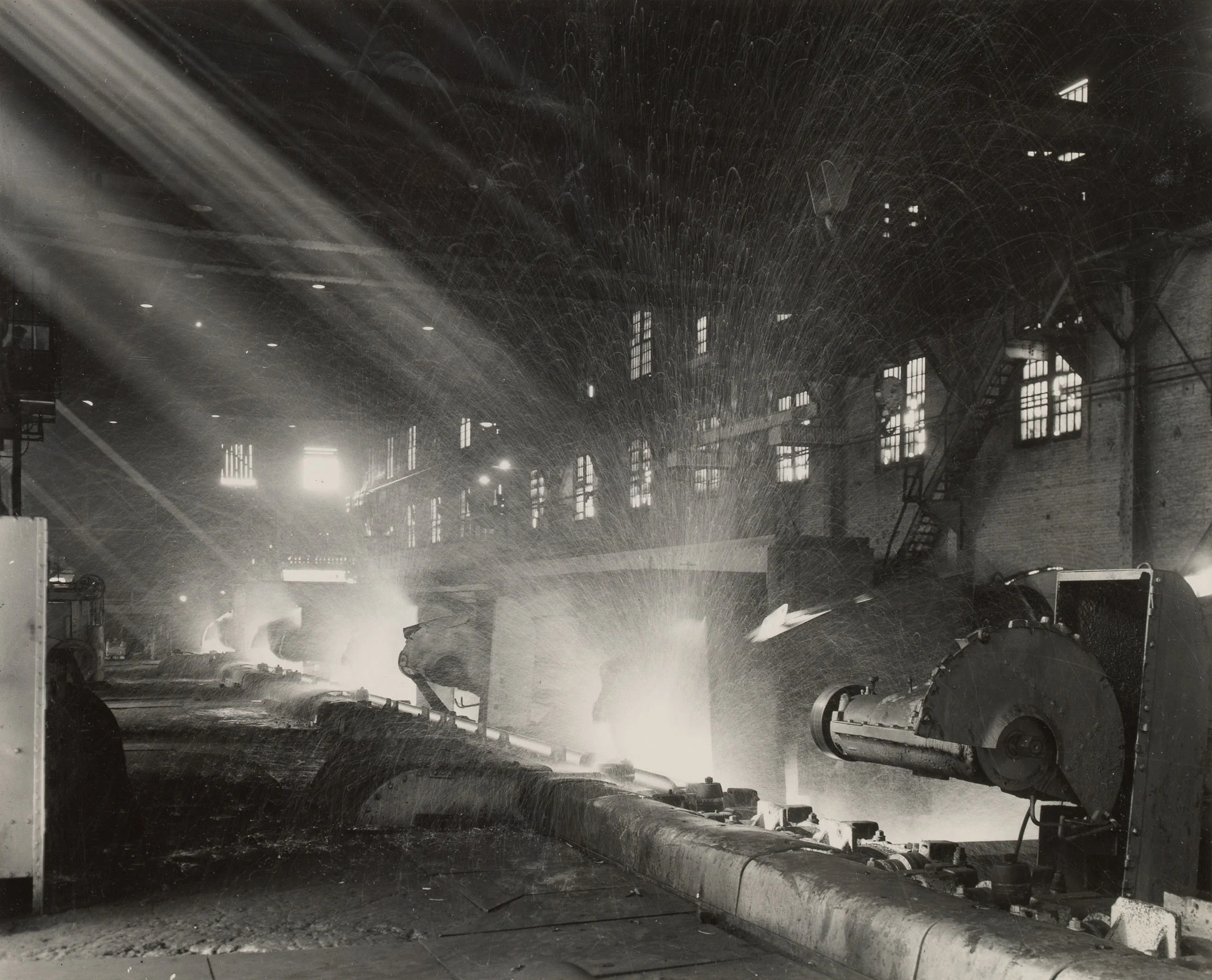 Sparks fly as hot saws cut glowing steel rails into 39-foot sections at Gary Steel Works.