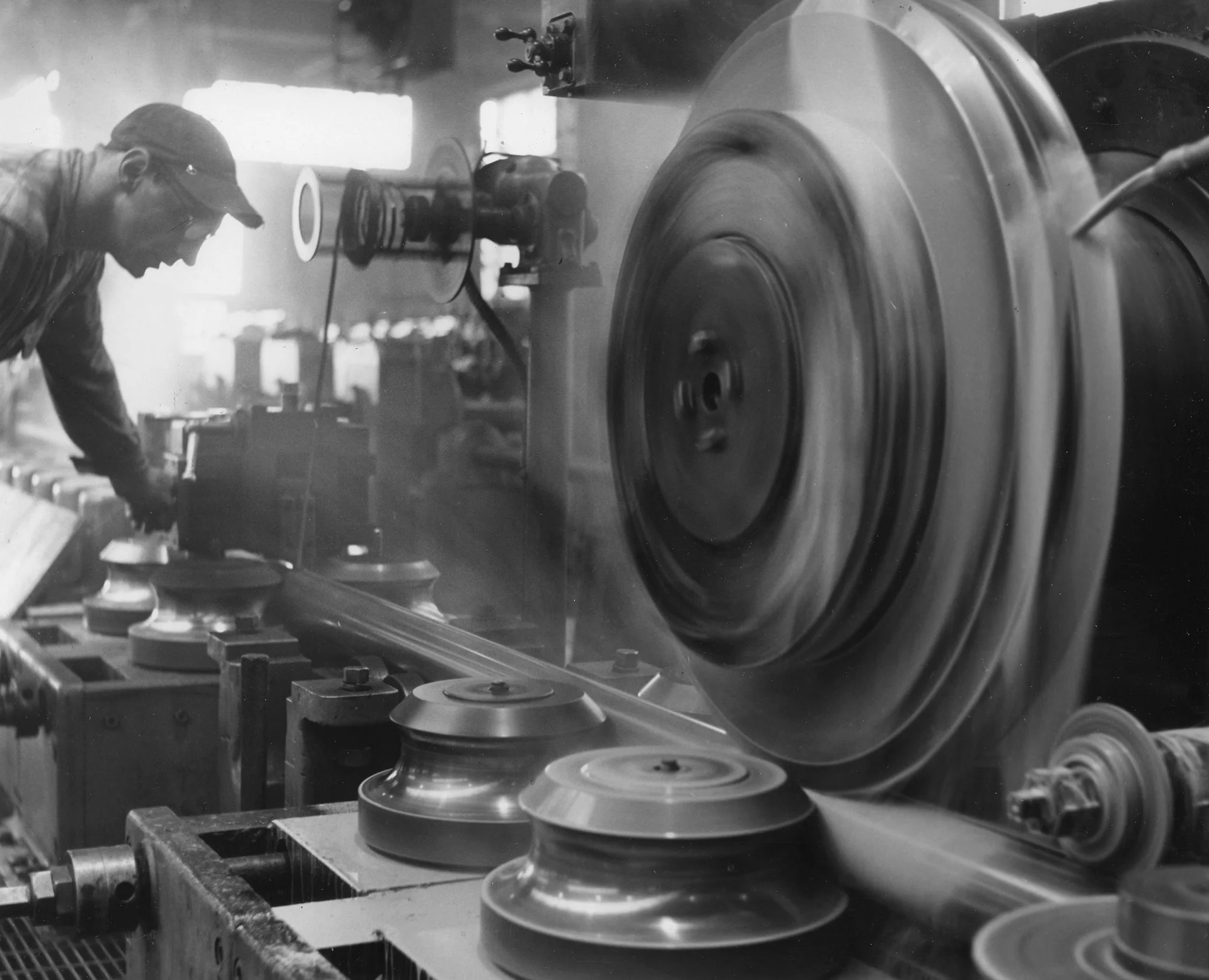 Worker monitors high-speed rollers and spinning weld wheel during tube welding at Gary Works in Gary, Indiana.