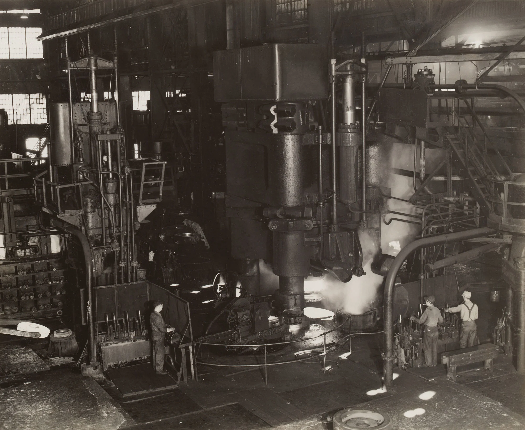 Workers operate forging press in wheel mill at Gary Steel Works, shaping preheated steel blocks into wheel blanks.