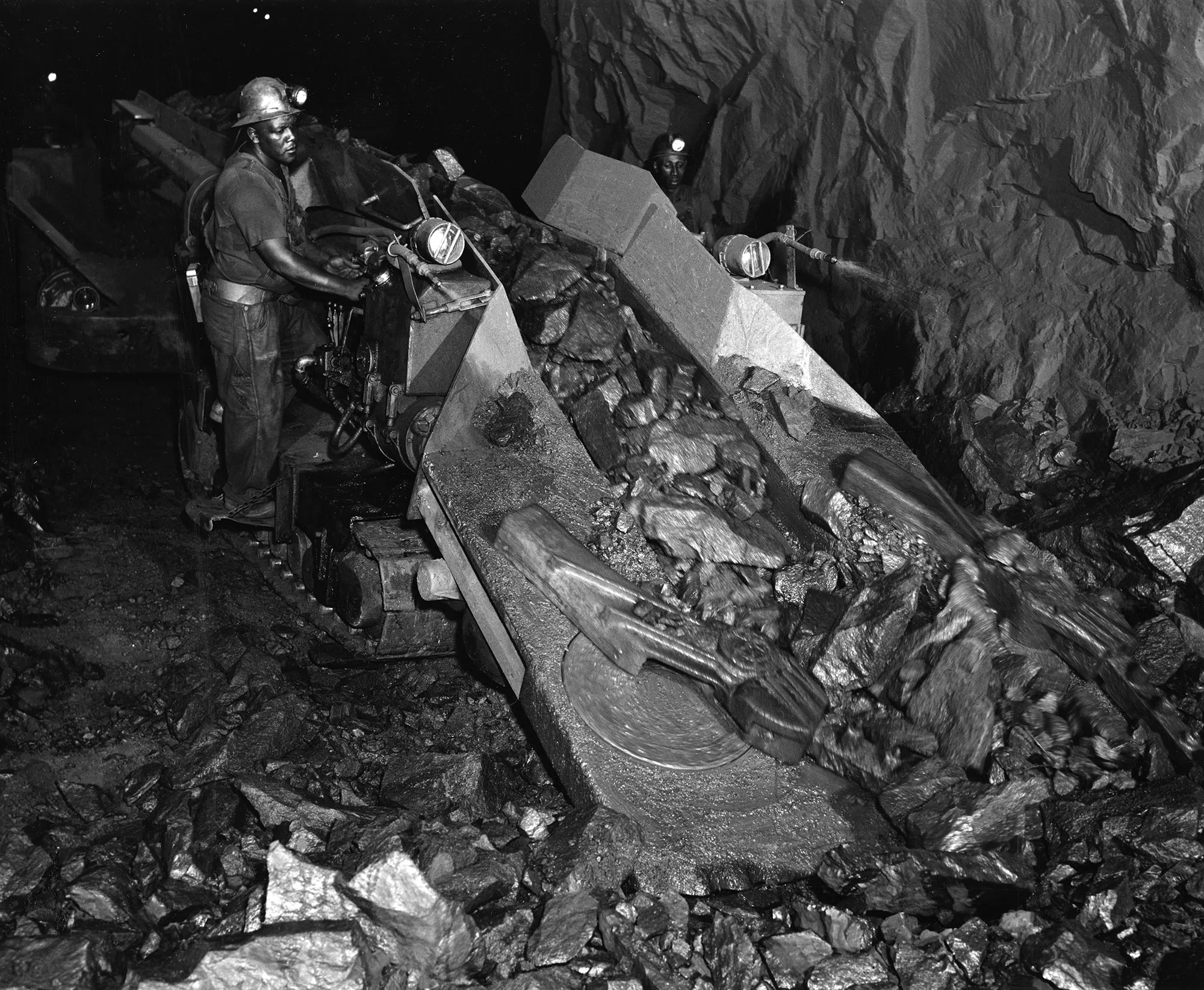 Miner operates machinery to scoop loose iron ore inside an underground tunnel at Tennessee Coal, Iron and Railroad Co. in Alabama.