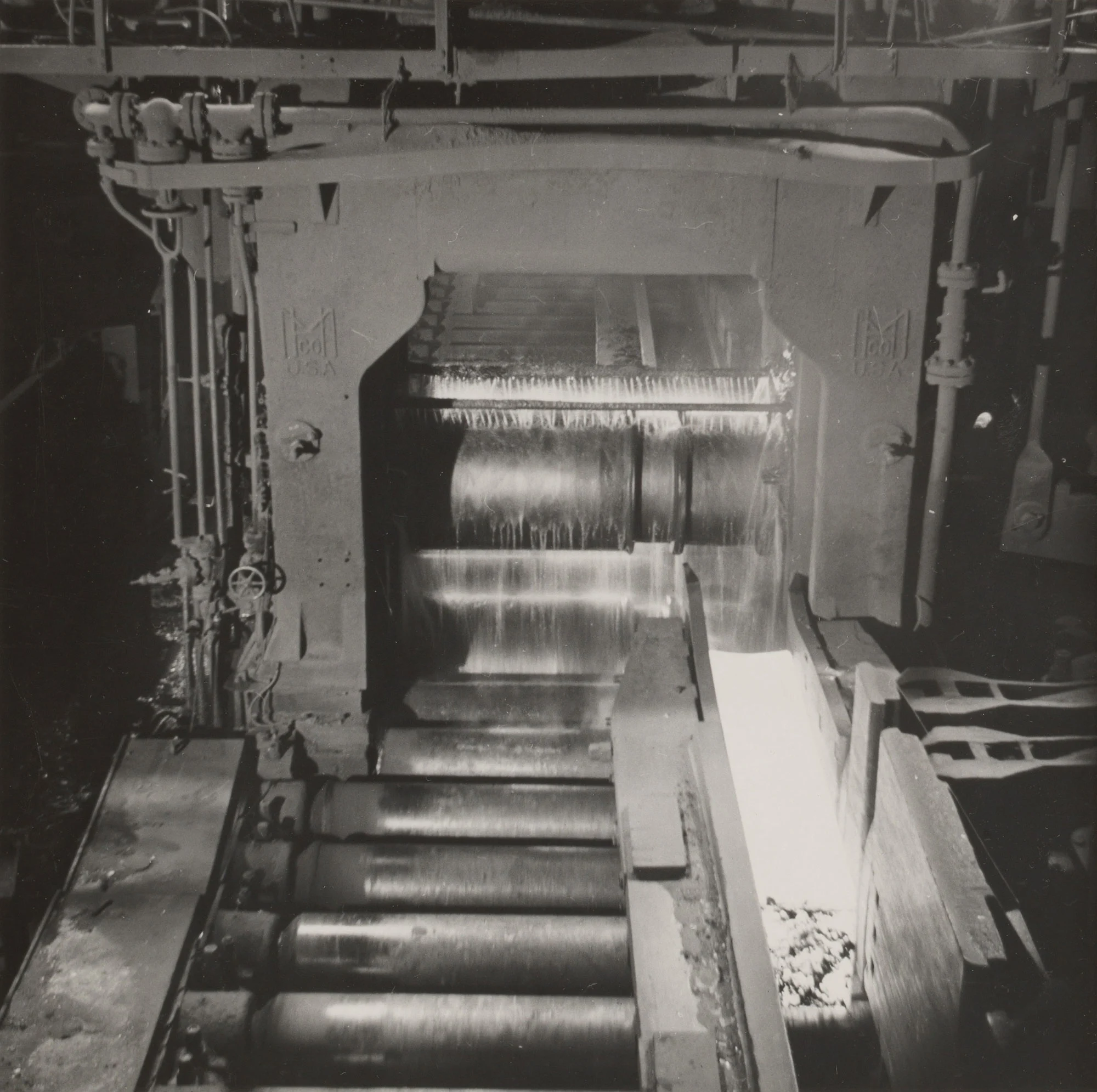 Glowing steel ingot passes through second rolling stage in 44-inch blooming mill at Gary Steel Works.