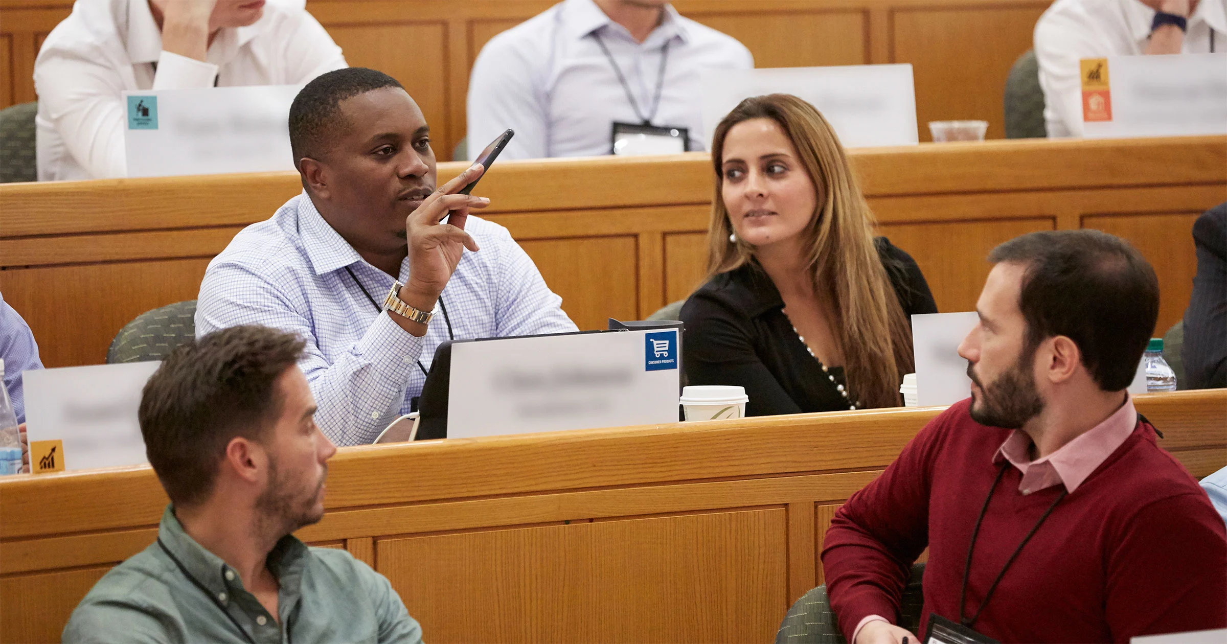 Executives asking question during lecture with other participants listening intently