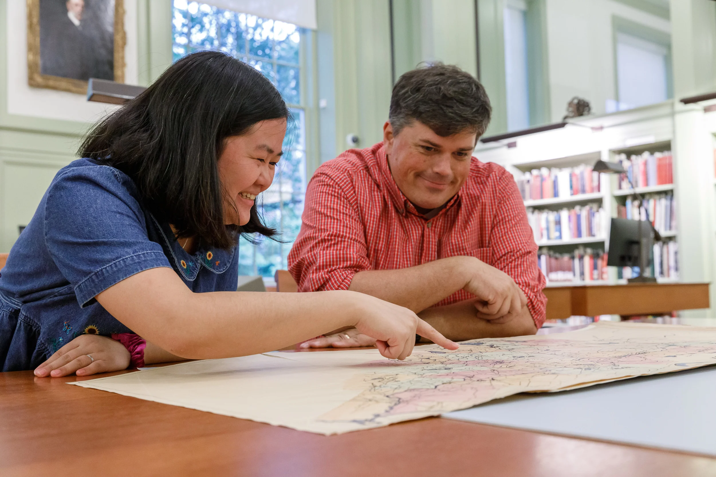 Researcher pointing at collection material with colleague looking on