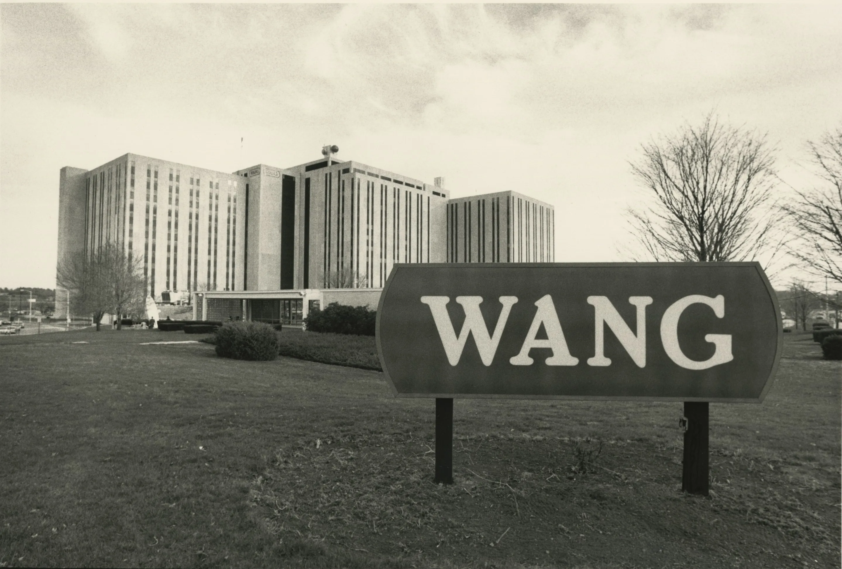 A large commercial building in the background with a sign in the foreground that says "WANG"