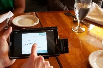 A customer pays his bill using Toast