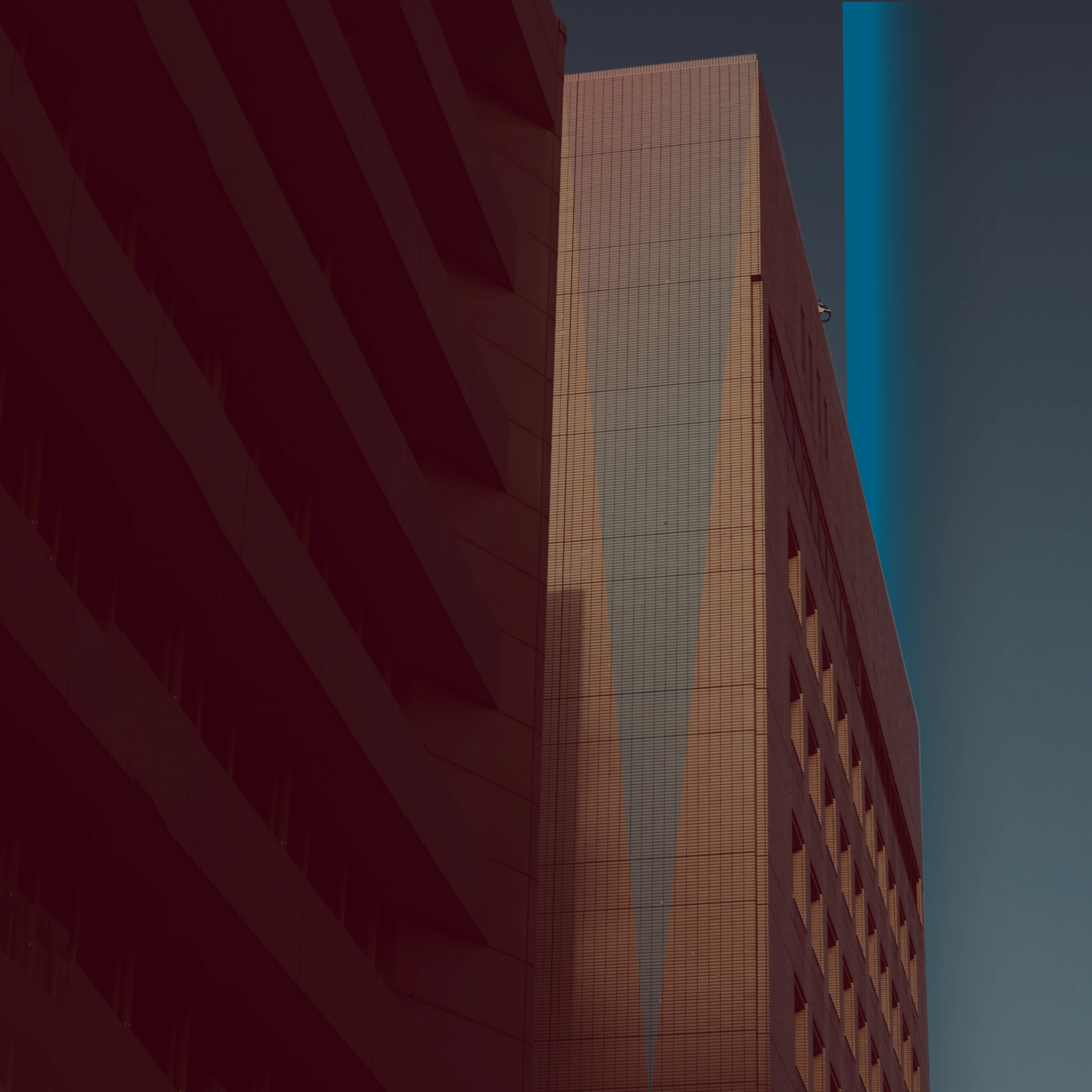 Buildings in shadow with reddish tint and blue lines.
