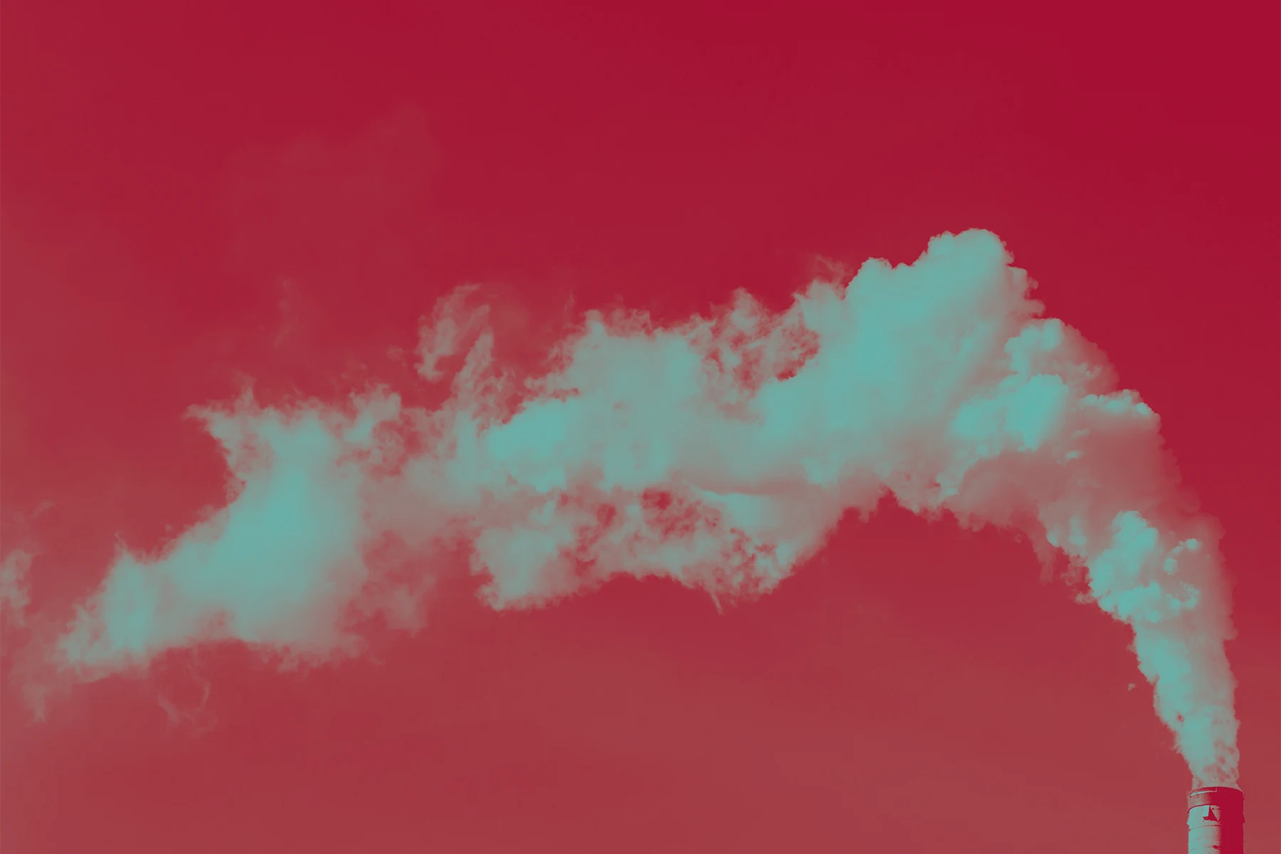 A single industrial smokestack is the far right of the image. Teal-tinted smoke comes out of it in a plume that drifts horizontally across the frame. The sky behind it is a deep red hue.