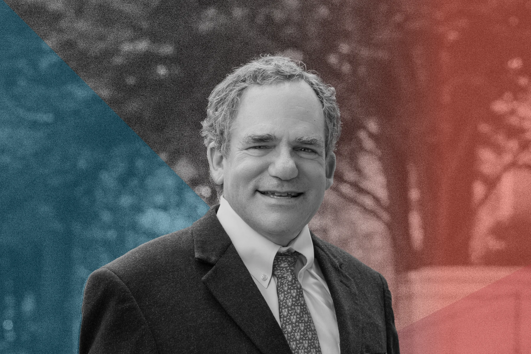 Black-and-white portrait of smiling man with wavy hair, dark suit jacket, white shirt and patterned tie. He's standing outside in front of a staircase and tree. Translucent overlays in teal and red form diagonal shapes across background of blurred trees.