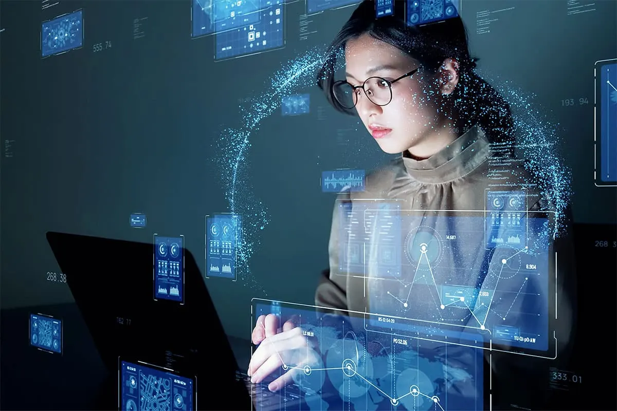 Business professional works on a laptop surrounded by digital data visualizations and futuristic interface graphics.