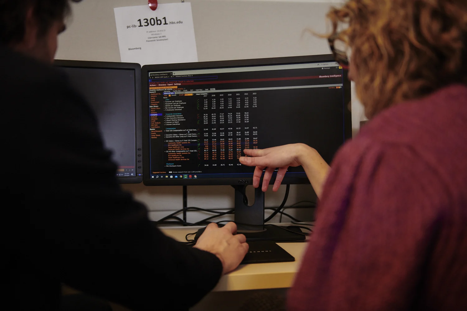 Photo showing two users from behind at a Bloomberg terminal.