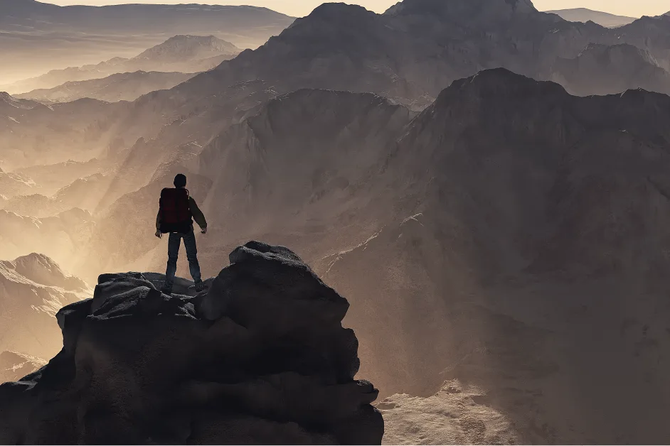 Person with a red backpack stands on a rocky cliff overlooking a vast, sunlit mountain range.