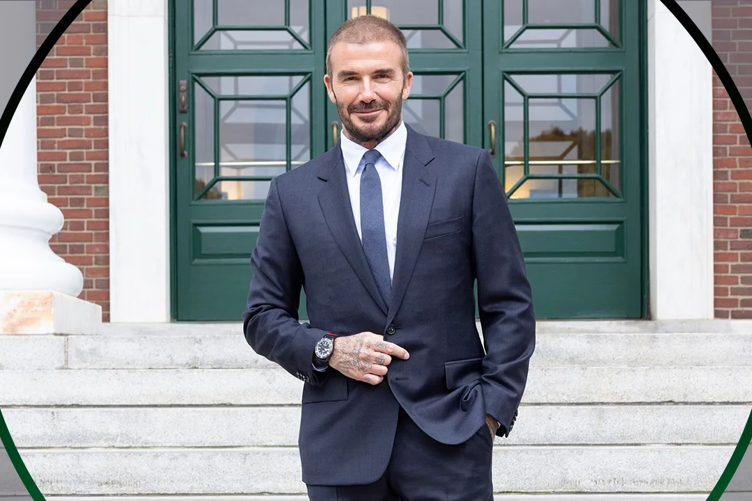 David Beckham wearing a suit in front of a green door