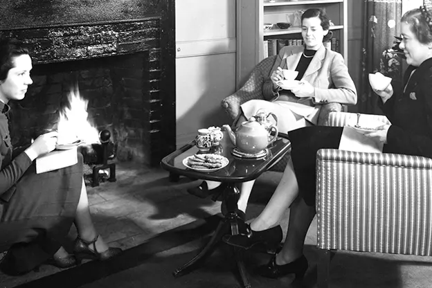 Radcliffe College students seated near a fireplace, Putnam House, 1937.