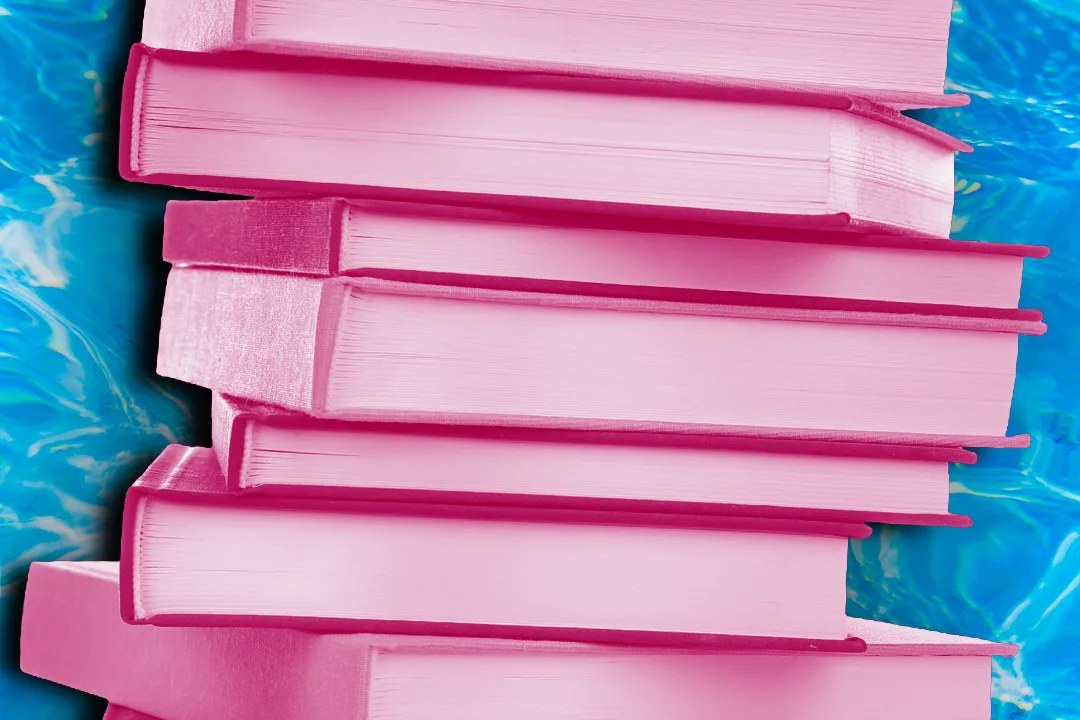 Stack of books, shaded in tones of pink, against blue pool water.
