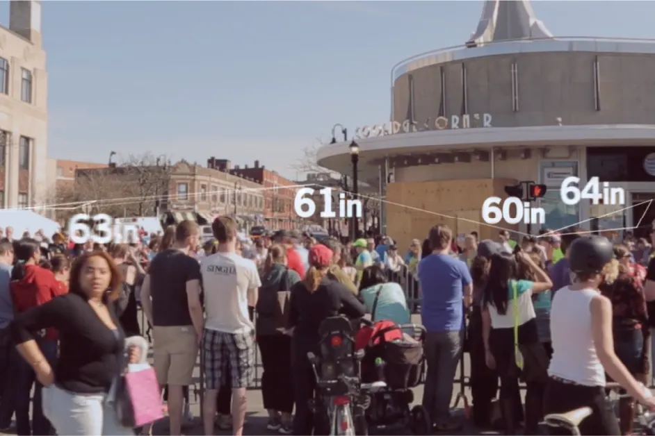 Crowd gathered in front of a building, with height measurements labeled above several people.