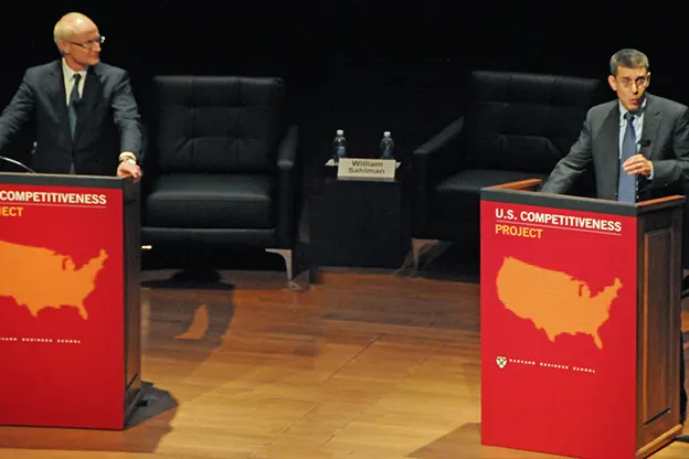 Michael E. Porter and Jan W. Rivkin on a podium behind lecterns with U.S Competitiveness Project logo including a USA map and Harvard Business School name