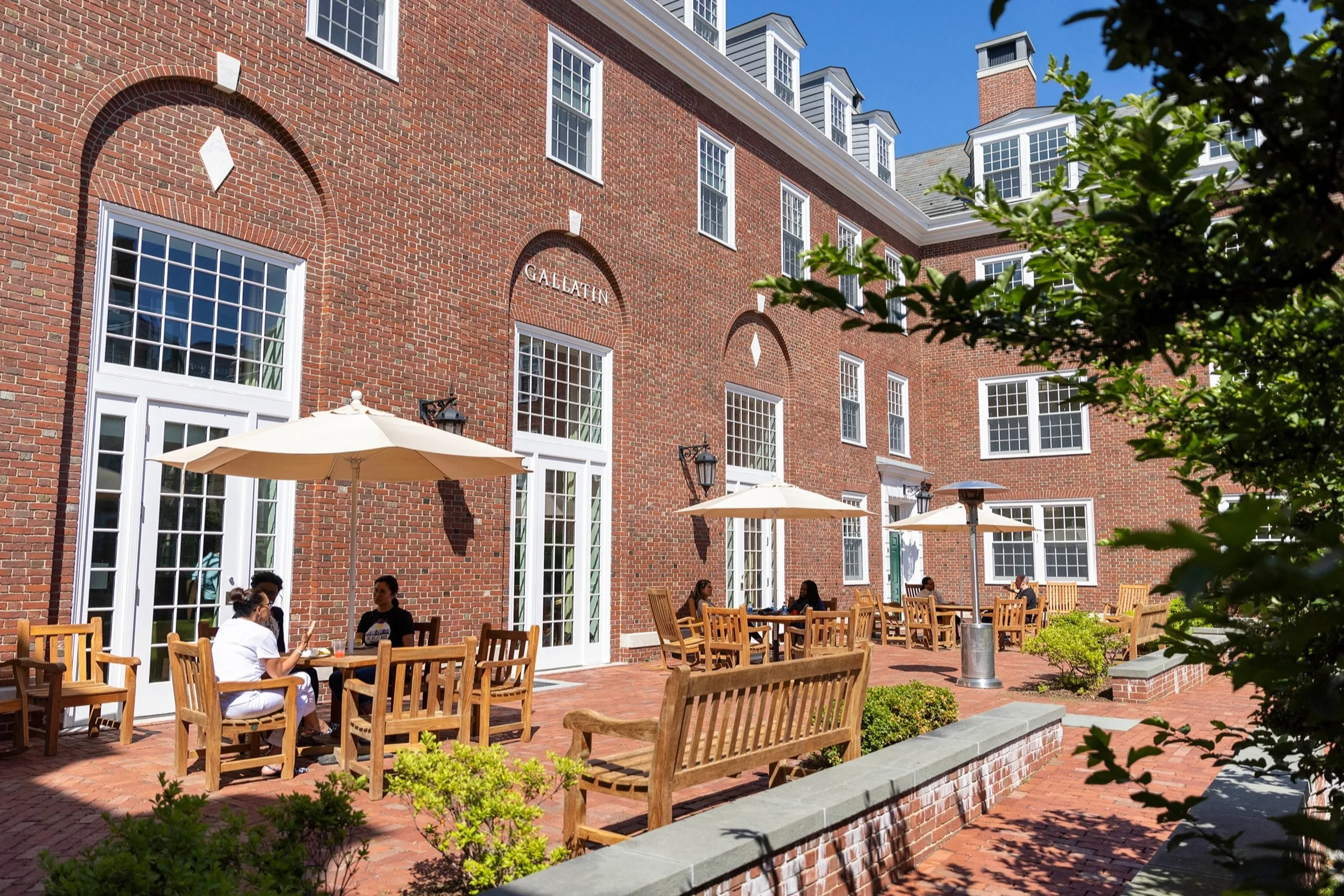 MBA students continue the discussion in Gallatin Hall's courtyard.