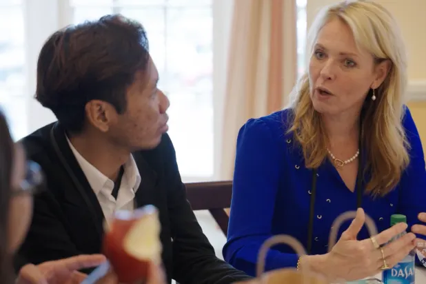 Man listening to blonde woman speaking in professional setting