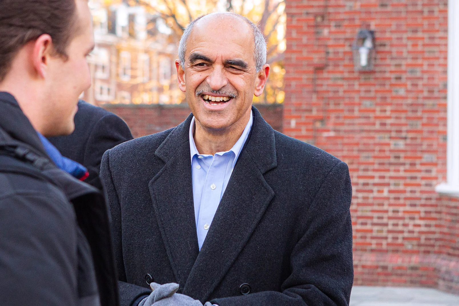 Dean Srikant Datar speaking with students outdoors on campus