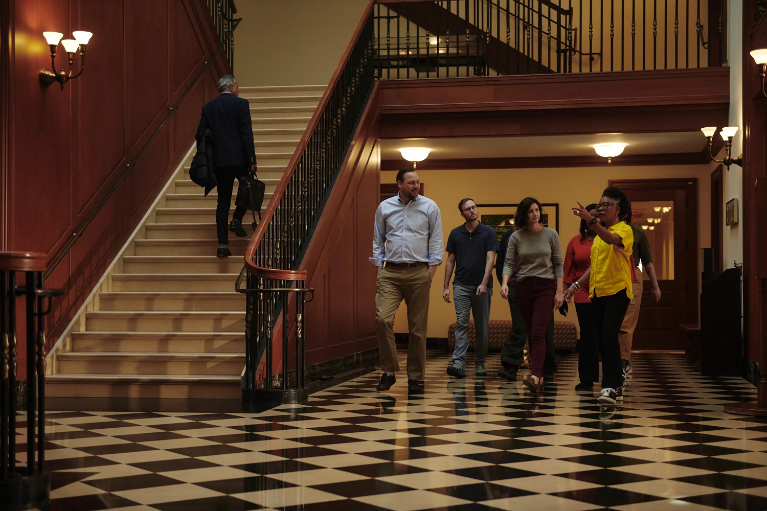 Group of staff walking across checkered Library floor