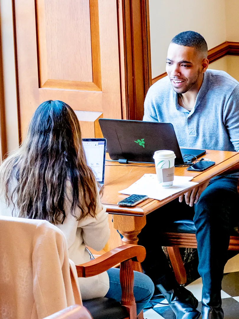 A group of three Research Associates study together on their laptops.